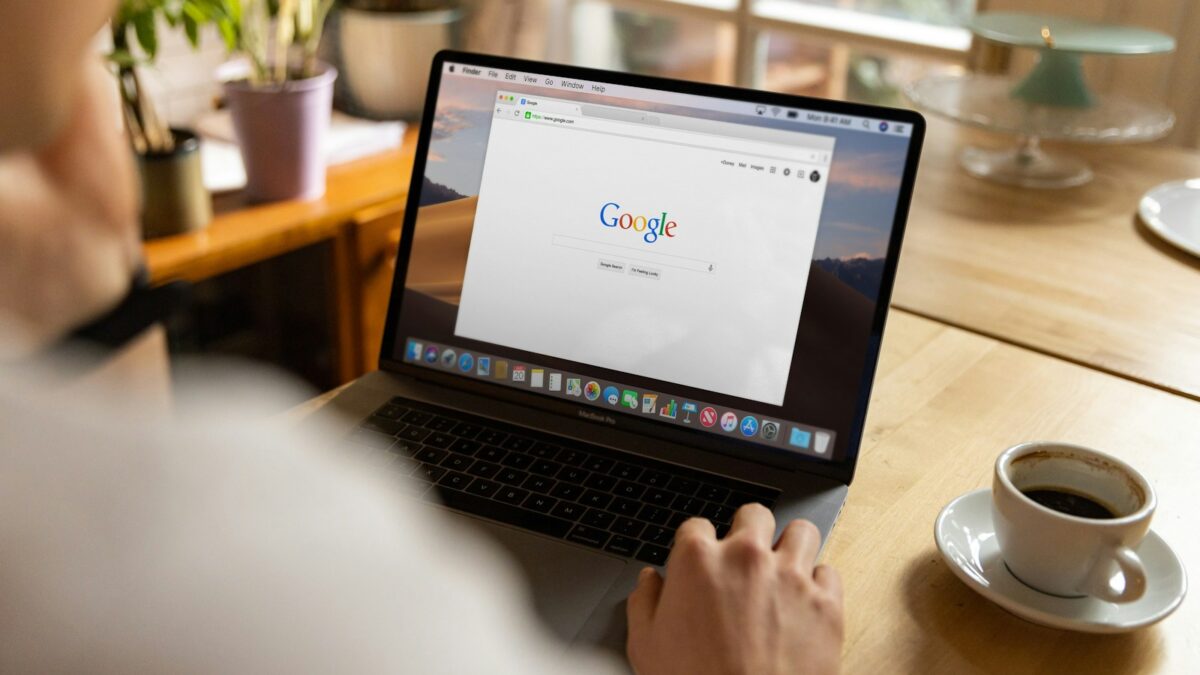 person using macbook pro on table